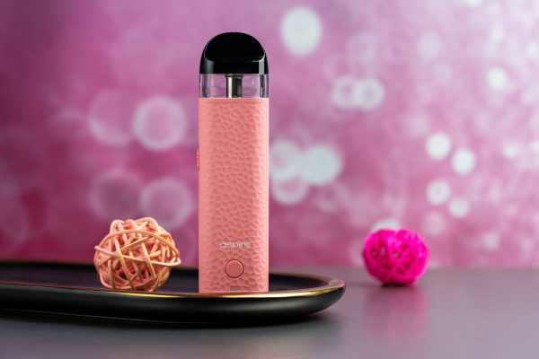Aspire Minican 4 粉色主機擺拍於夢幻粉紫背景，展現時尚氣質風格