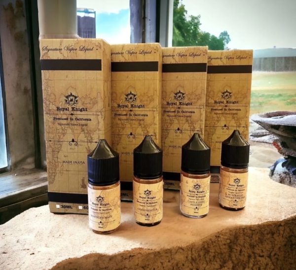 Royal Knight 皇家系列煙油擺放於戶外窗台石面，陽光灑落呈現自然與復古融合風格 　說明重點：窗邊陽光自然光源與石材質地突顯煙油瓶身與盒裝設計細節。